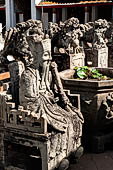 Bangkok Wat Arun - Detail of the precint of the sacred area of the ubosot with chinese noble man sitting on chair. 